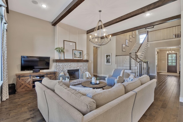 living room with plenty of natural light, dark hardwood / wood-style floors, a brick fireplace, and a notable chandelier