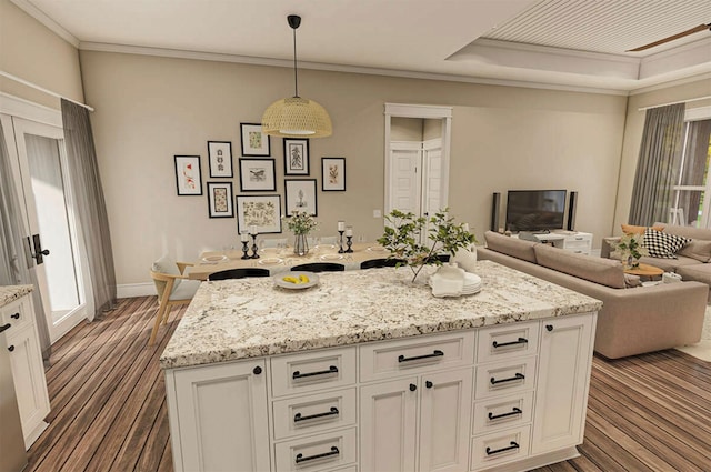 kitchen with crown molding, dark hardwood / wood-style flooring, white cabinets, and decorative light fixtures