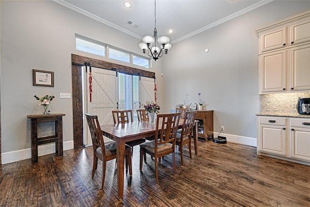 dining room with a barn door, a chandelier, dark hardwood / wood-style floors, and ornamental molding