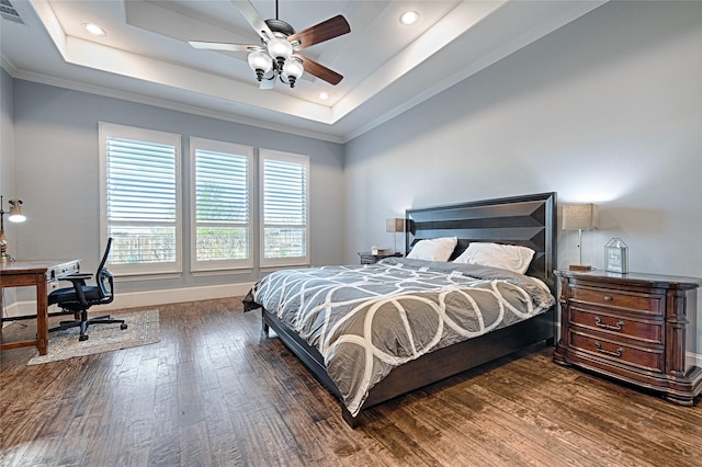 bedroom with dark hardwood / wood-style flooring, a raised ceiling, ceiling fan, and ornamental molding