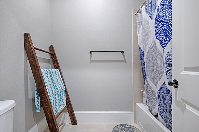 bathroom featuring tile patterned flooring, shower / bath combo, and toilet