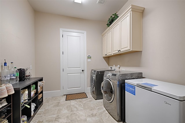 clothes washing area featuring cabinets and independent washer and dryer