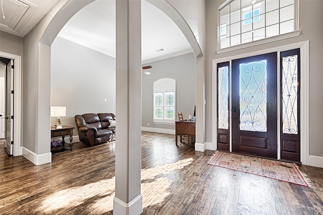 entrance foyer featuring ceiling fan, dark wood-type flooring, and ornamental molding