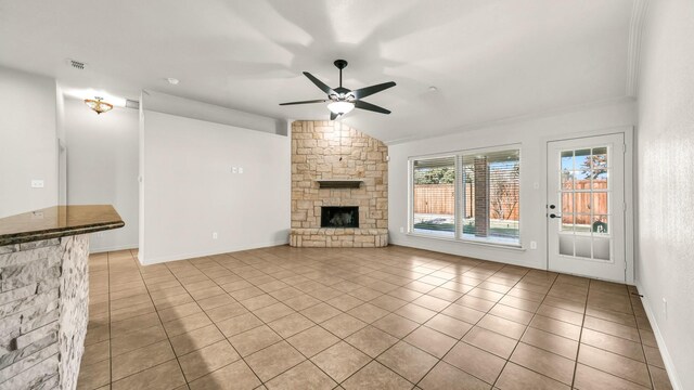 unfurnished living room with ceiling fan, a fireplace, and light tile patterned floors