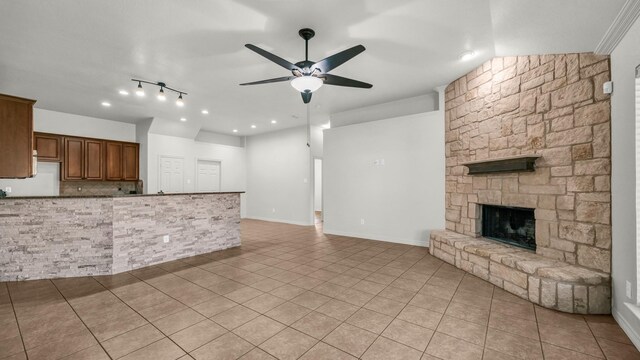 unfurnished living room featuring a fireplace, visible vents, a ceiling fan, vaulted ceiling, and tile patterned floors