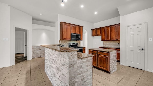 kitchen featuring stone counters, electric range, a center island, and light tile patterned floors