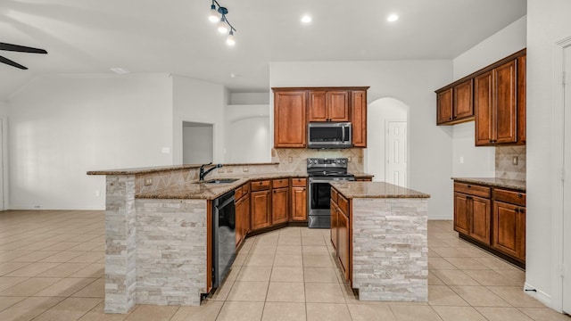 kitchen with kitchen peninsula, appliances with stainless steel finishes, light stone counters, sink, and light tile patterned floors