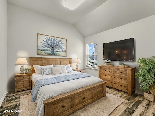 bedroom featuring vaulted ceiling, baseboards, and wood finished floors