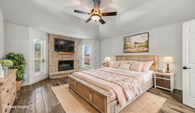 914 Randall Rd, Weatherford, TX 76087 - bedroom featuring a stone fireplace, multiple windows, lofted ceiling, and wood finished floors