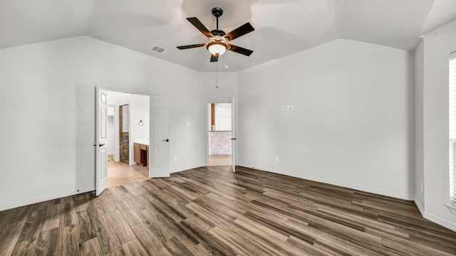 unfurnished bedroom featuring ensuite bath, ceiling fan, hardwood / wood-style floors, and vaulted ceiling