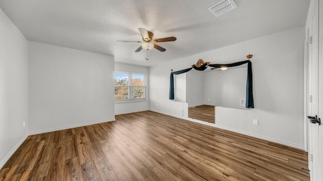 interior space featuring ceiling fan, hardwood / wood-style floors, and a textured ceiling