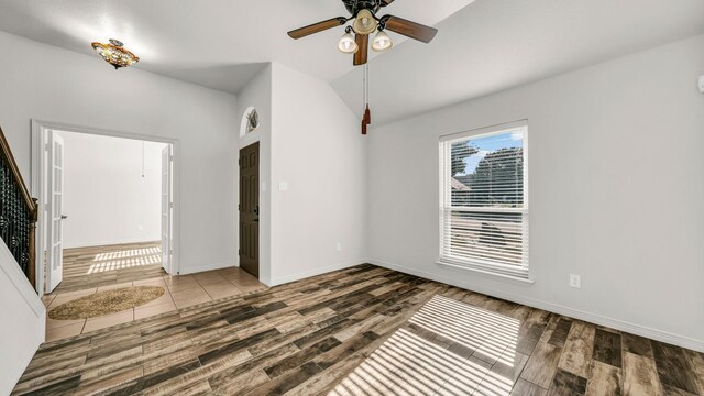 unfurnished room with a ceiling fan, lofted ceiling, baseboards, and wood finished floors