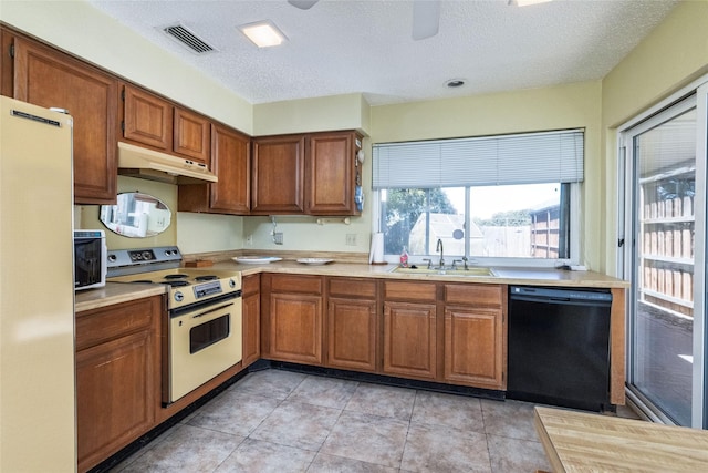 kitchen featuring sink, electric range, fridge, black dishwasher, and light tile patterned flooring