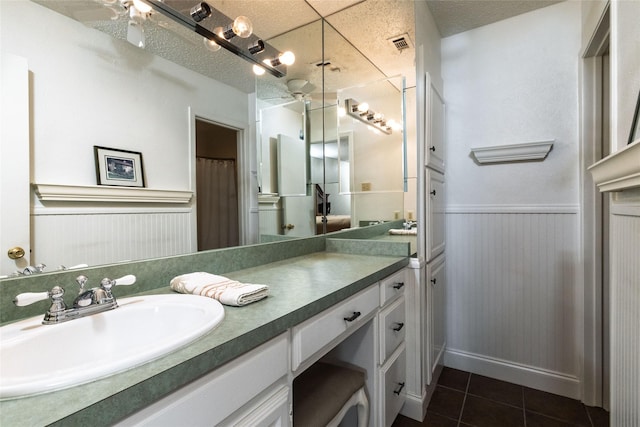 bathroom featuring vanity, tile patterned flooring, and a textured ceiling