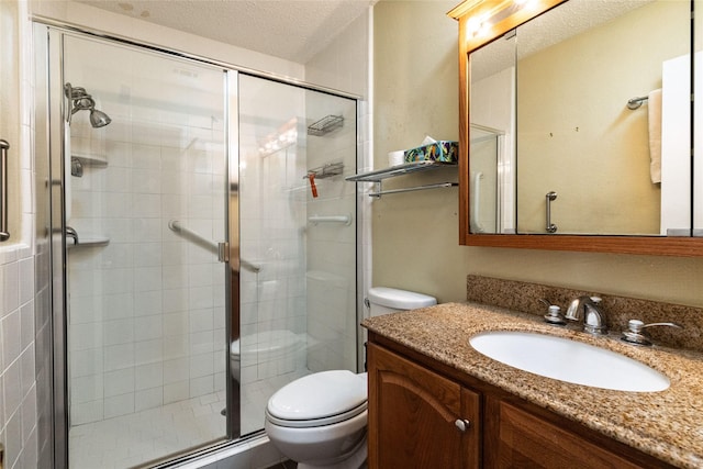 bathroom with vanity, a shower with shower door, toilet, and a textured ceiling