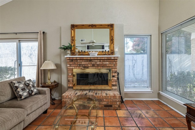 tiled living room with a brick fireplace and a healthy amount of sunlight