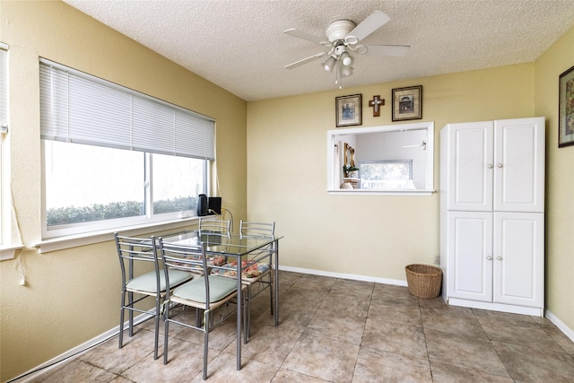 dining area with light tile patterned flooring, a textured ceiling, and ceiling fan