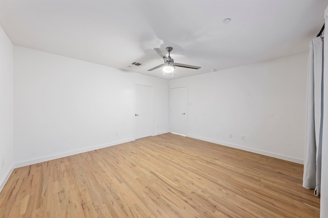 unfurnished room featuring baseboards, visible vents, light wood finished floors, and ceiling fan