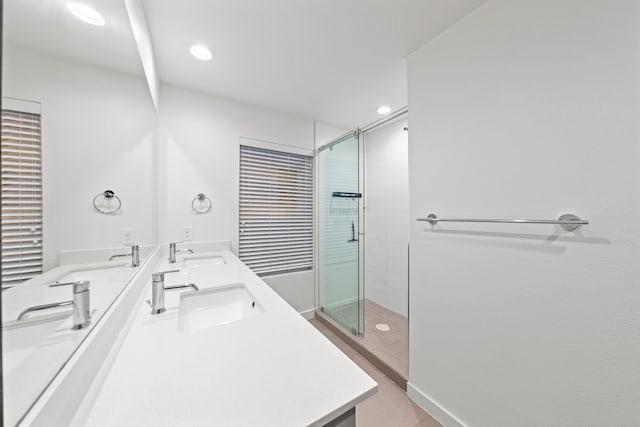 full bath with double vanity, recessed lighting, a stall shower, and a sink