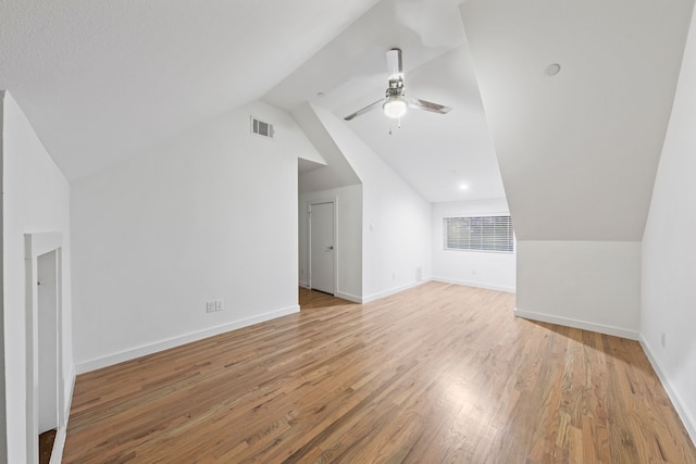 additional living space featuring light wood finished floors, visible vents, baseboards, vaulted ceiling, and a ceiling fan
