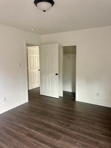 unfurnished bedroom with a closet and dark hardwood / wood-style floors