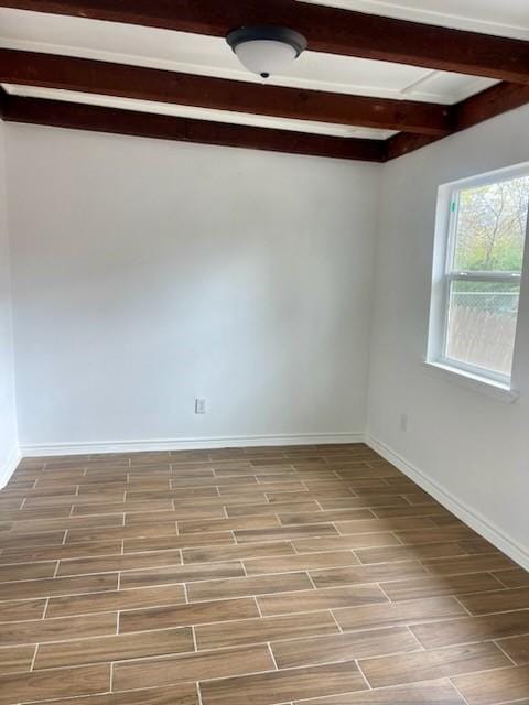 unfurnished room featuring beam ceiling