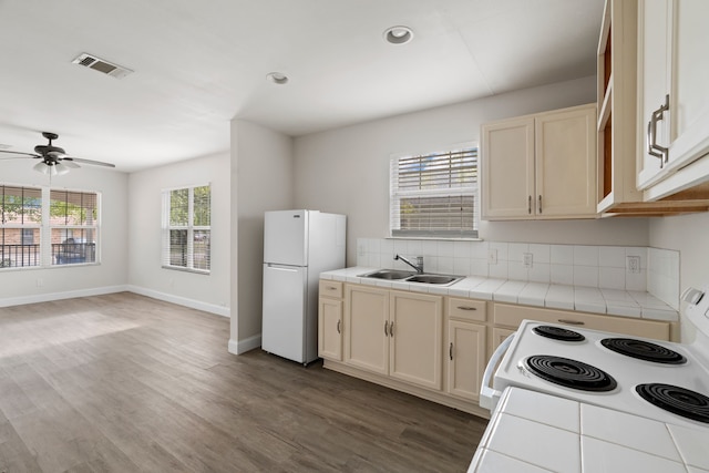 kitchen with ceiling fan, tile counters, sink, dark hardwood / wood-style floors, and white appliances