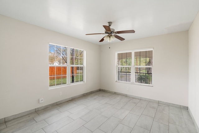 empty room featuring a wealth of natural light and ceiling fan