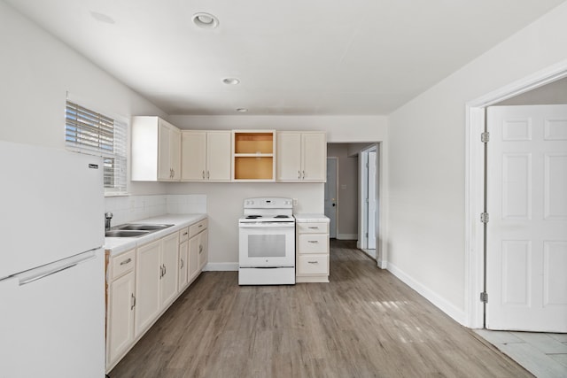 kitchen featuring decorative backsplash, sink, white appliances, and light hardwood / wood-style flooring