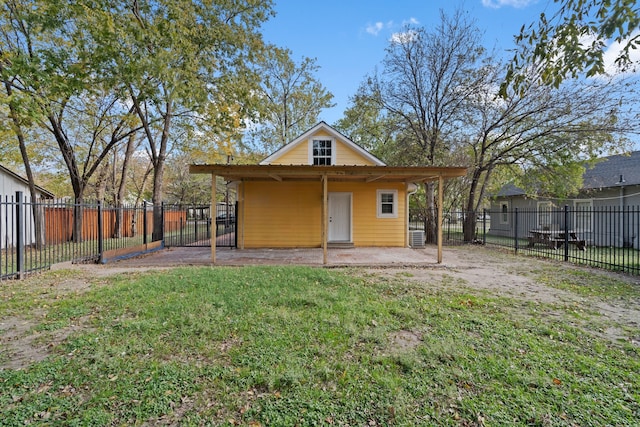 rear view of property featuring central AC unit and a lawn