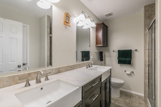 bathroom with tile patterned flooring, vanity, a shower with door, and toilet