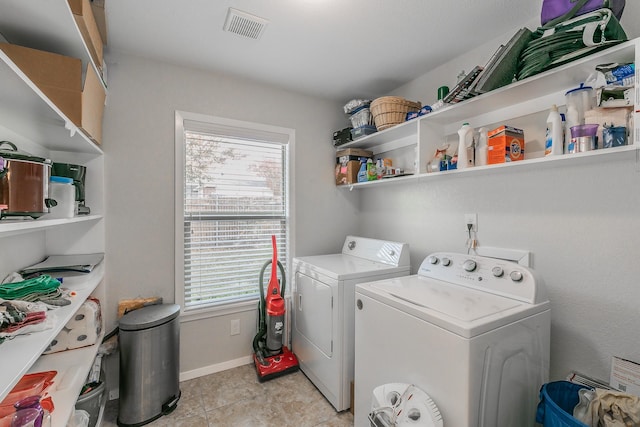 laundry area with washer and clothes dryer and light tile patterned floors