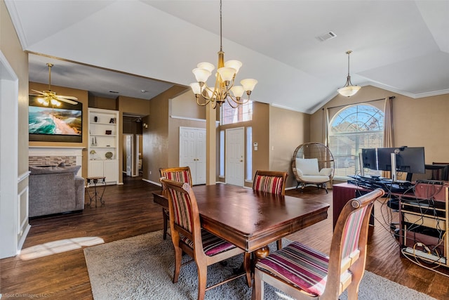 dining area with ceiling fan with notable chandelier, dark hardwood / wood-style floors, and vaulted ceiling