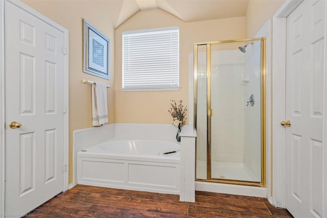 bathroom featuring hardwood / wood-style floors, plus walk in shower, and vaulted ceiling