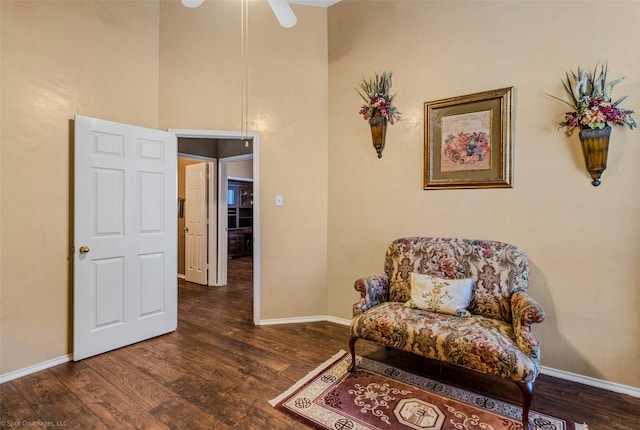 living area with ceiling fan and dark wood-type flooring