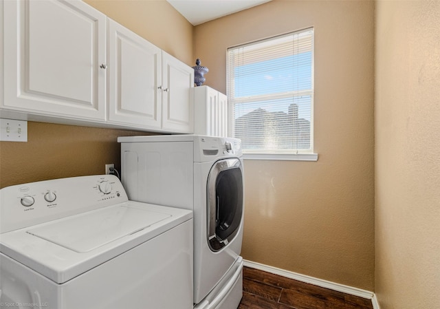 laundry area featuring cabinets, washing machine and dryer, and dark hardwood / wood-style floors