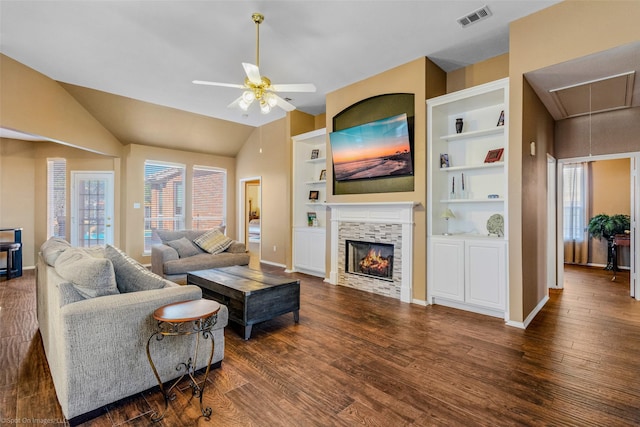 living room featuring built in shelves, dark hardwood / wood-style flooring, vaulted ceiling, and ceiling fan