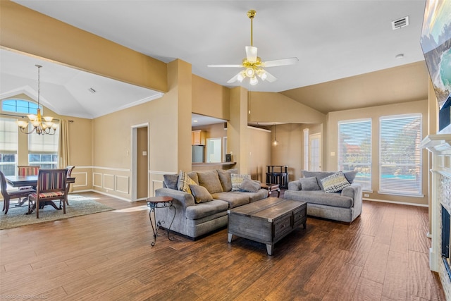 living room with dark hardwood / wood-style flooring, ceiling fan with notable chandelier, vaulted ceiling, and ornamental molding