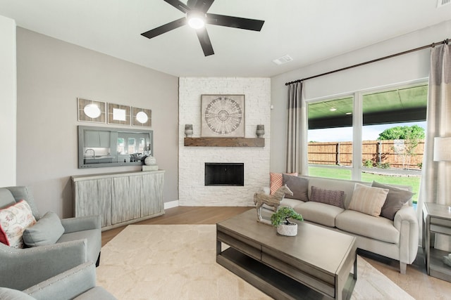 living room with ceiling fan, hardwood / wood-style floors, and a fireplace