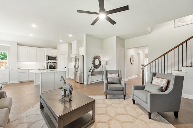 living room featuring ceiling fan and light wood-type flooring