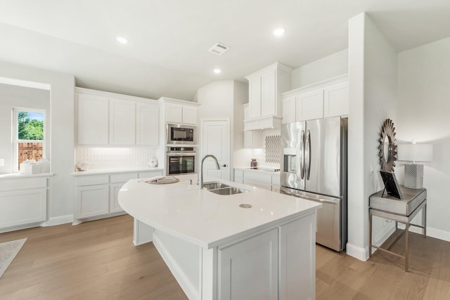 kitchen featuring appliances with stainless steel finishes, sink, a center island with sink, and white cabinets