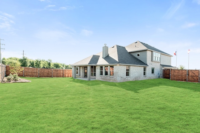 back of property with a yard and a patio area