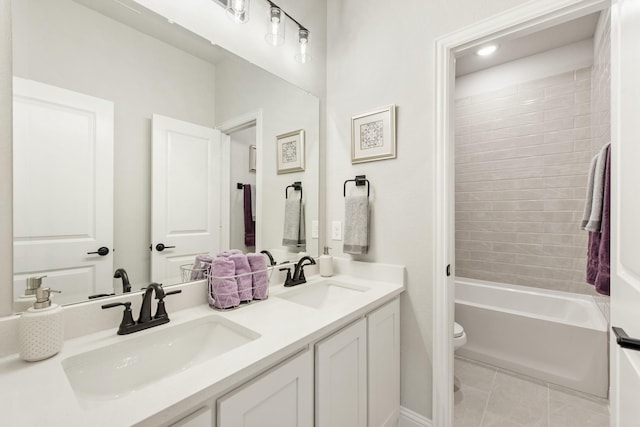 full bathroom featuring tile patterned flooring, vanity, tiled shower / bath, and toilet