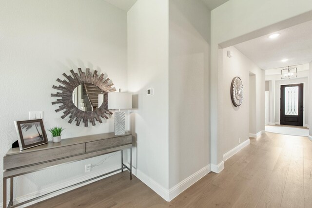 hall featuring a notable chandelier and hardwood / wood-style flooring