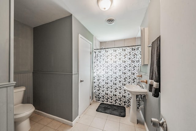 bathroom featuring tile patterned floors, curtained shower, and toilet