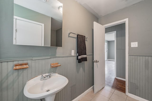 bathroom featuring wood walls, wood-type flooring, and sink