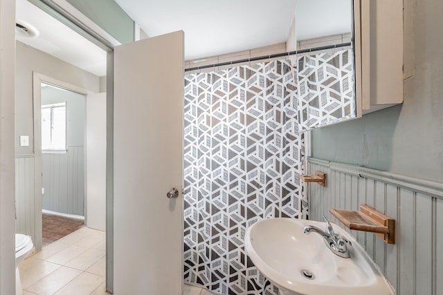 bathroom featuring tile patterned flooring, toilet, and sink