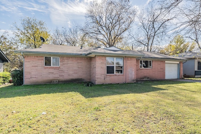 rear view of house with a garage and a yard