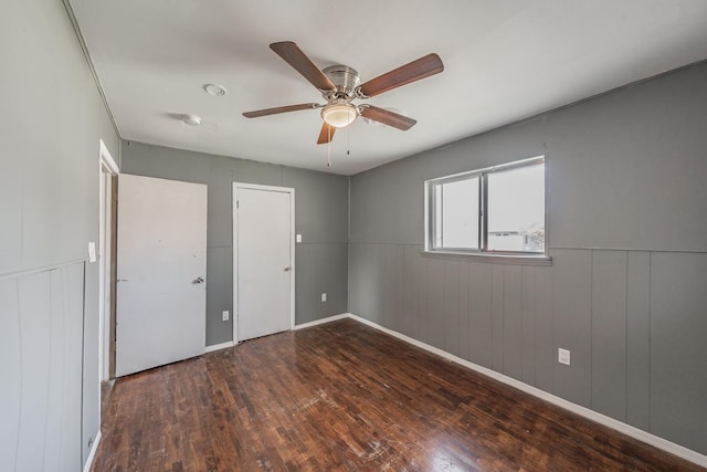 unfurnished bedroom featuring ceiling fan and dark wood-type flooring