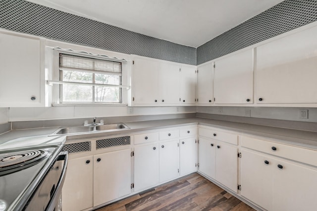 kitchen featuring dark hardwood / wood-style floors, white cabinetry, stainless steel range with electric cooktop, and sink